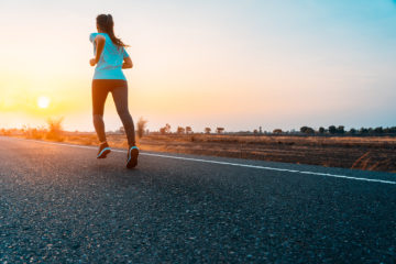ragazza che corre al tramonto in campagna - mindful running: cos'è e quali sono i benefici
